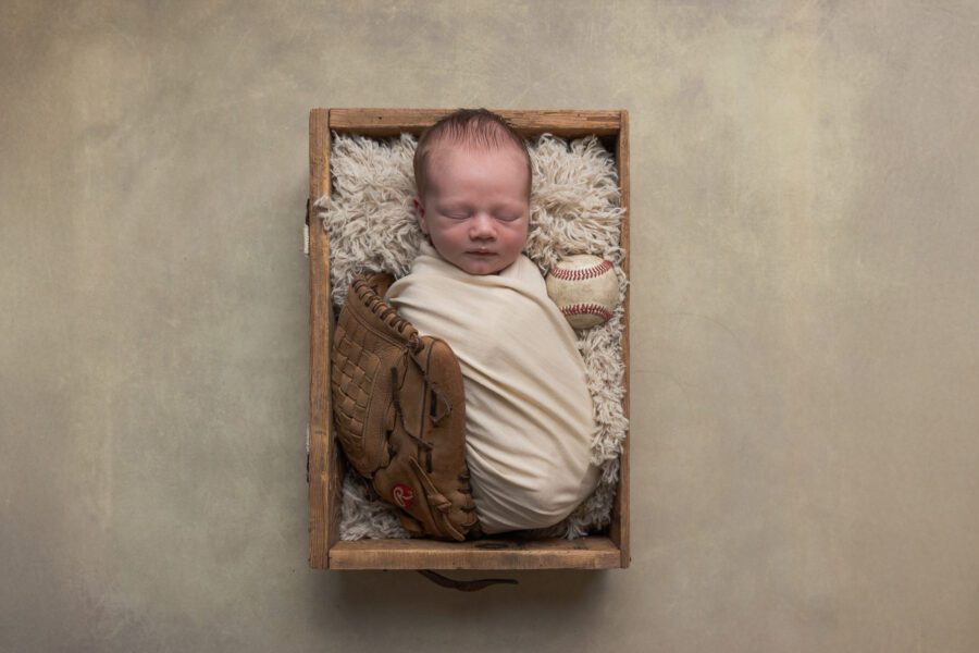 Professional newborn photo session with a baseball theme